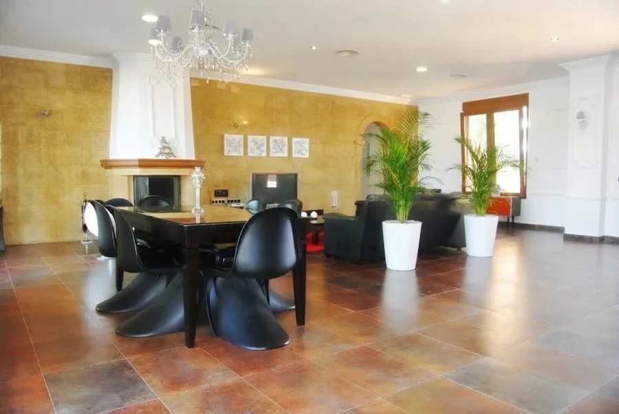 Salón-comedor con chimenea, mesa de comedor y ventanas al jardín