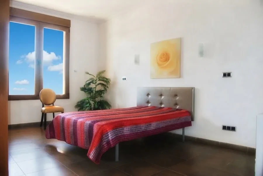 Dormitorio luminoso con cama de matrimonio y ventana